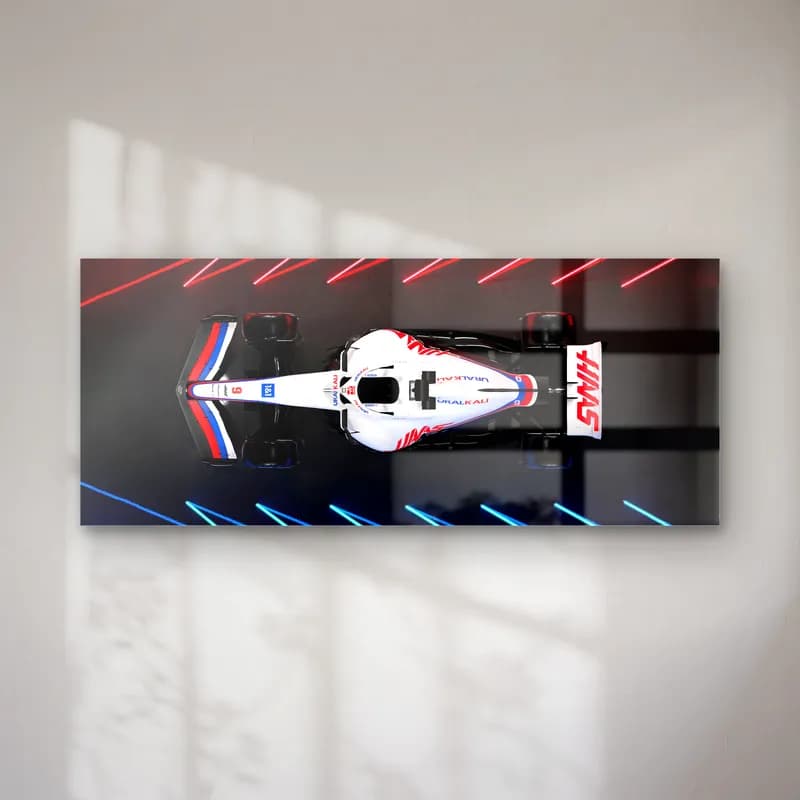 Neon Pistte Haas F1 cam tablo — Neon çizgili koyu zeminde yukarıdan görülen beyaz kırmızı Haas F1 aracı