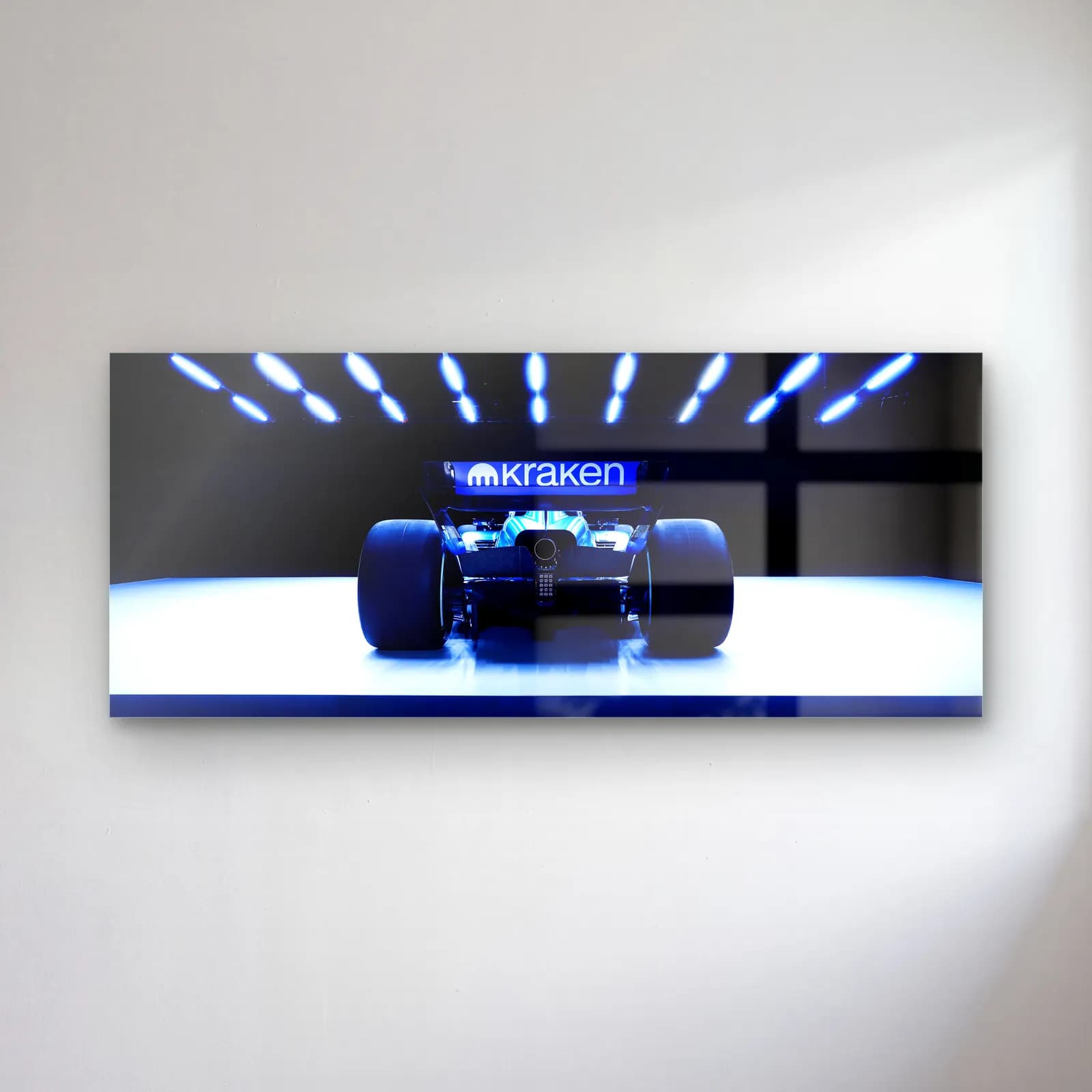 Williams F1 Aracı Arkadan cam tablo — Mavi spotlar altında beyaz platformda arkadan görünen Williams F1 aracı