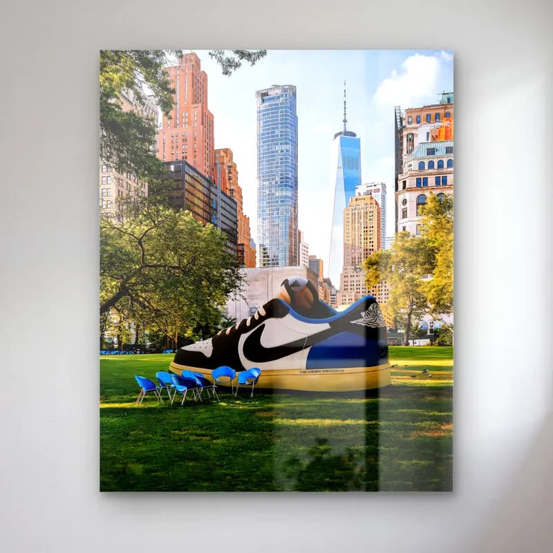 New York Parkında Dev Nike Dunk cam tablo — New York gökdelenleri önünde yeşil parkta duran dev siyah beyaz Nike Dunk